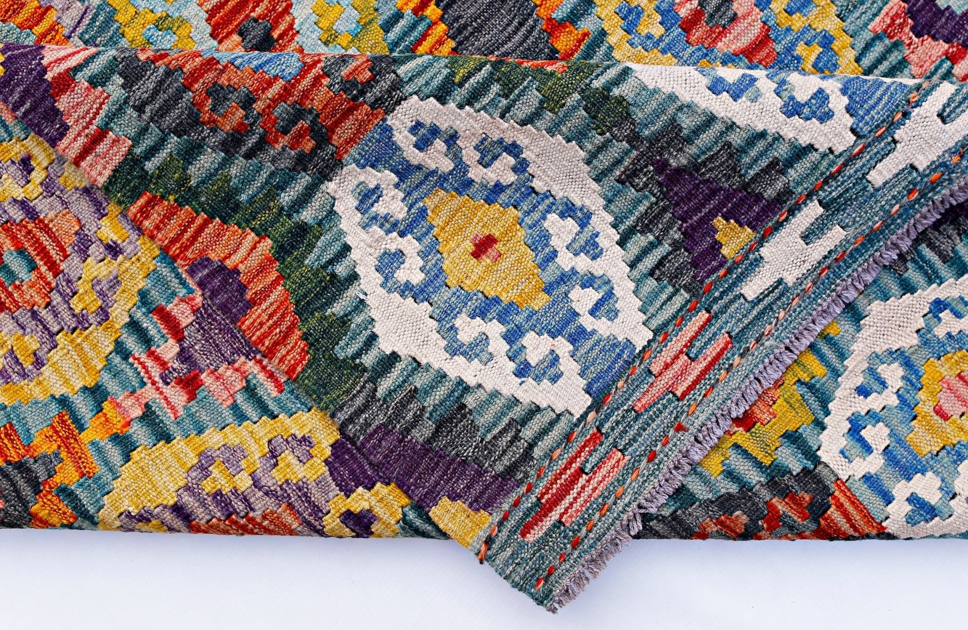 A handwoven Afghan Maimana kilim rug featuring a vibrant geometric pattern in wool.