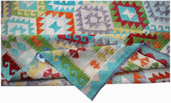 A handmade Afghan Maimana kilim rug featuring a vibrant geometric pattern in wool.