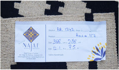 A handmade Afghan Maimana Kilim rug featuring a geometric black and cream pattern.