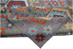 A handmade Afghan Maimana kilim rug featuring a grey background with colorful geometric patterns.