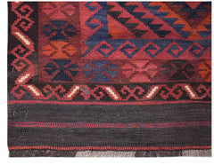 Handwoven Afghan Maimana kilim runner featuring geometric patterns in red, blue, and orange wool.