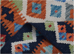 A handmade Afghan Maimana kilim runner featuring a geometric pattern in orange, blue, and green.