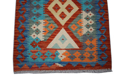 Handwoven Afghan Maimana wool runner featuring a vibrant geometric pattern in multi-colored tones.
