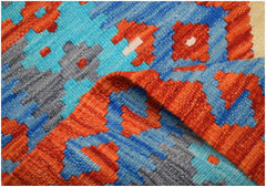 A close-up of a handmade Afghan Maimana kilim runner featuring geometric patterns in wool.