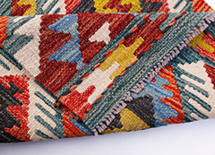 A folded Afghan Maimana kilim runner featuring a vibrant geometric pattern in wool.