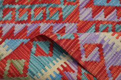 A handmade Afghan Maimana wool kilim runner featuring a vibrant geometric pattern.