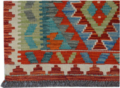 Handwoven Afghan Maimana kilim runner featuring a geometric pattern in red, blue, and green wool.