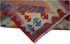 A handwoven Afghan Maimana kilim runner featuring a geometric pattern in vibrant wool colors.