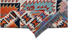 A handwoven Afghan Maimana Kilim runner featuring vibrant geometric patterns in wool.