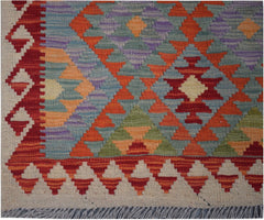 Handmade Afghan Maimana kilim runner featuring a vibrant geometric pattern in wool.