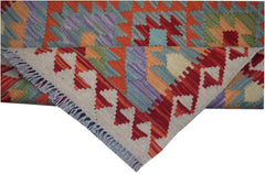 A handmade Afghan Maimana kilim runner featuring colorful geometric patterns and a fringed edge.
