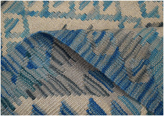 A handwoven Afghan Maimana wool kilim runner featuring a geometric pattern in blue and cream tones.