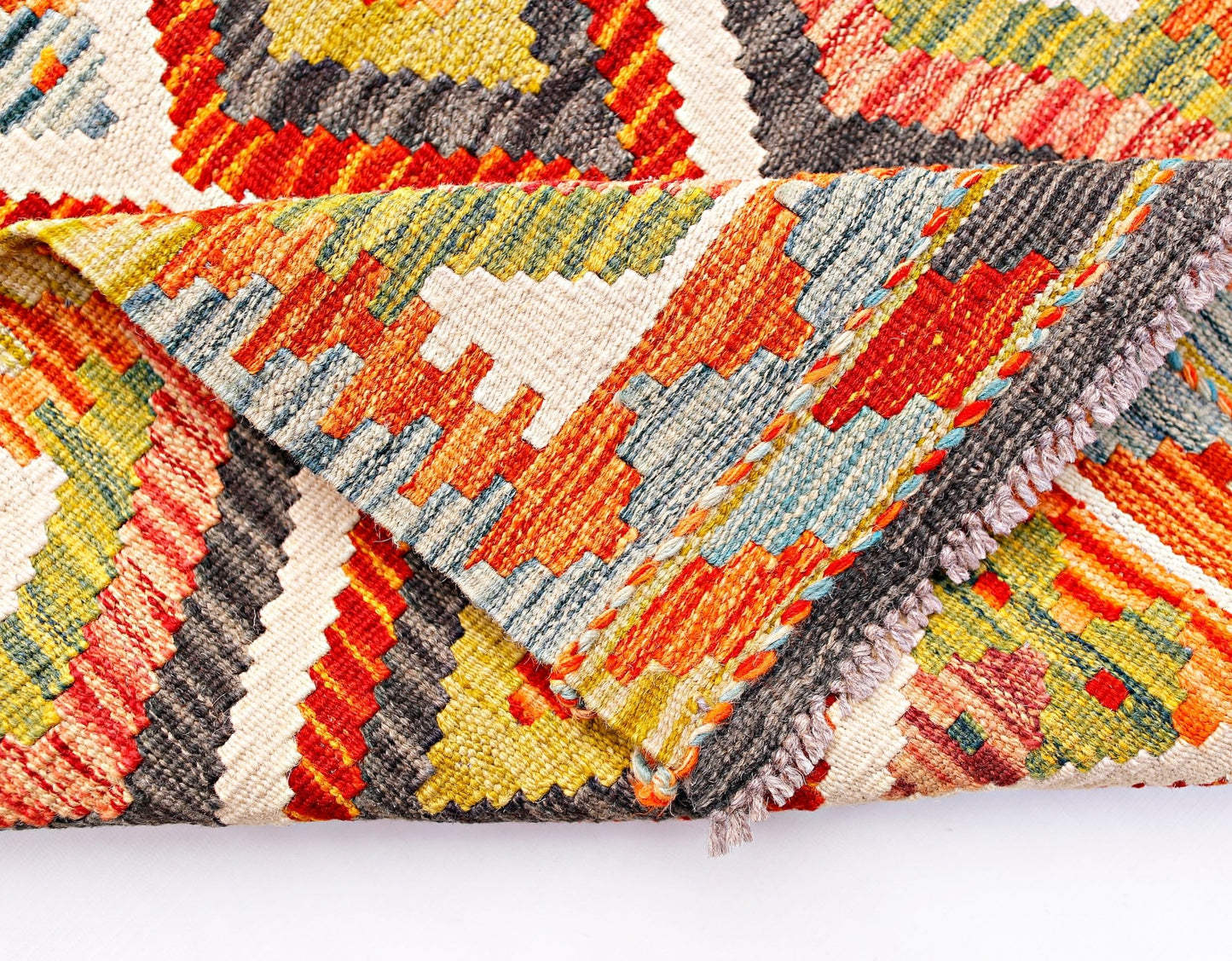 A handwoven Afghan Maimana wool kilim runner featuring a vibrant geometric pattern.