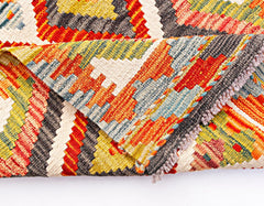 A handwoven Afghan Maimana wool kilim runner featuring a vibrant geometric pattern.