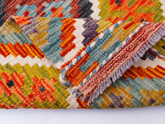 A handwoven Afghan Maimana kilim runner featuring vibrant geometric patterns in wool.