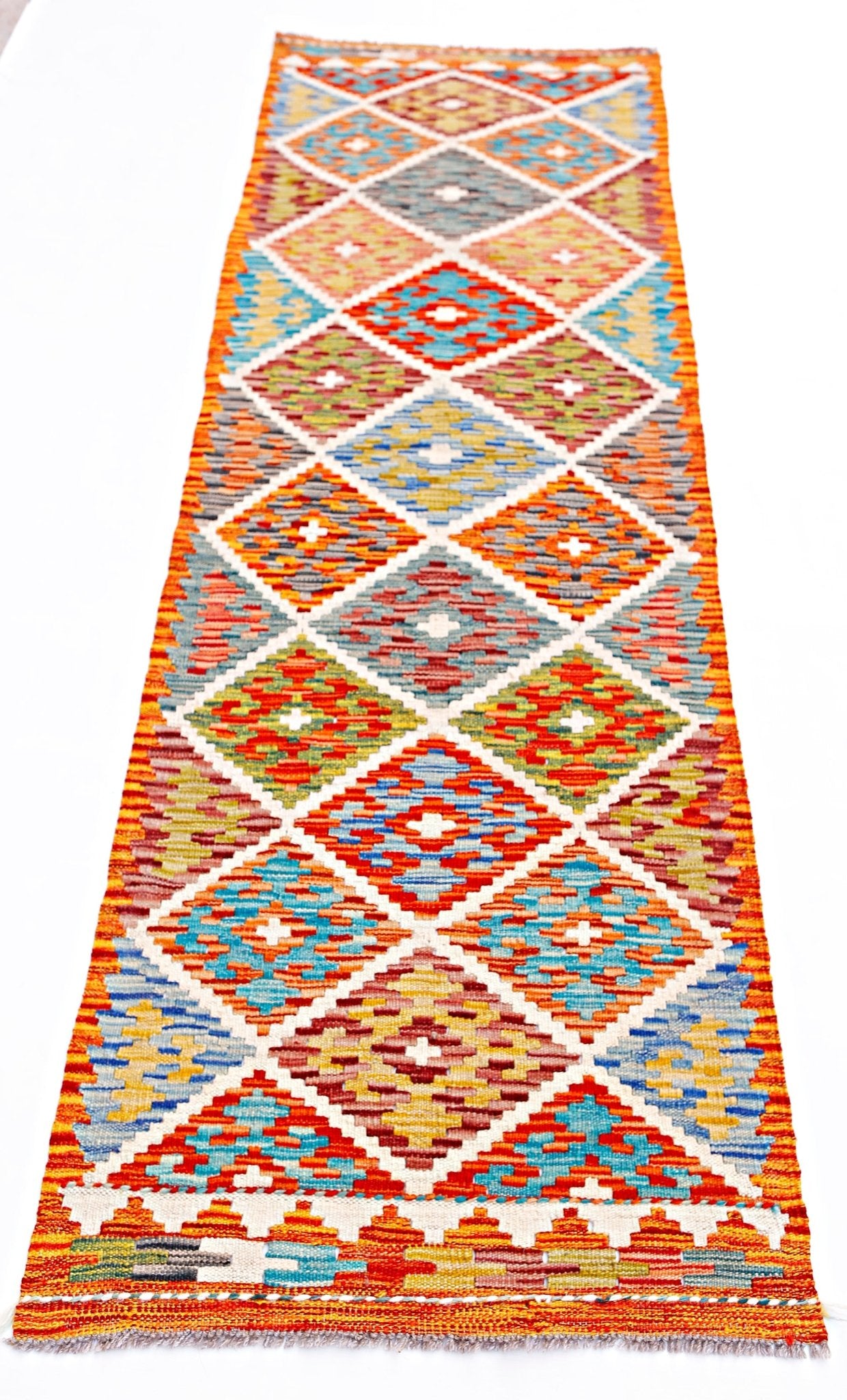 Handwoven Afghan Maimana wool runner rug featuring a colorful geometric diamond pattern.