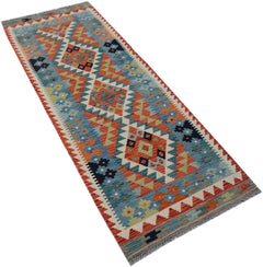 An Afghan Maimana Kilim runner featuring a geometric pattern in blue, orange, and green wool.