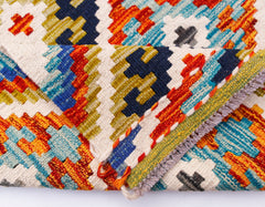 A handmade Afghan Maimana kilim runner featuring a vibrant geometric pattern in wool.