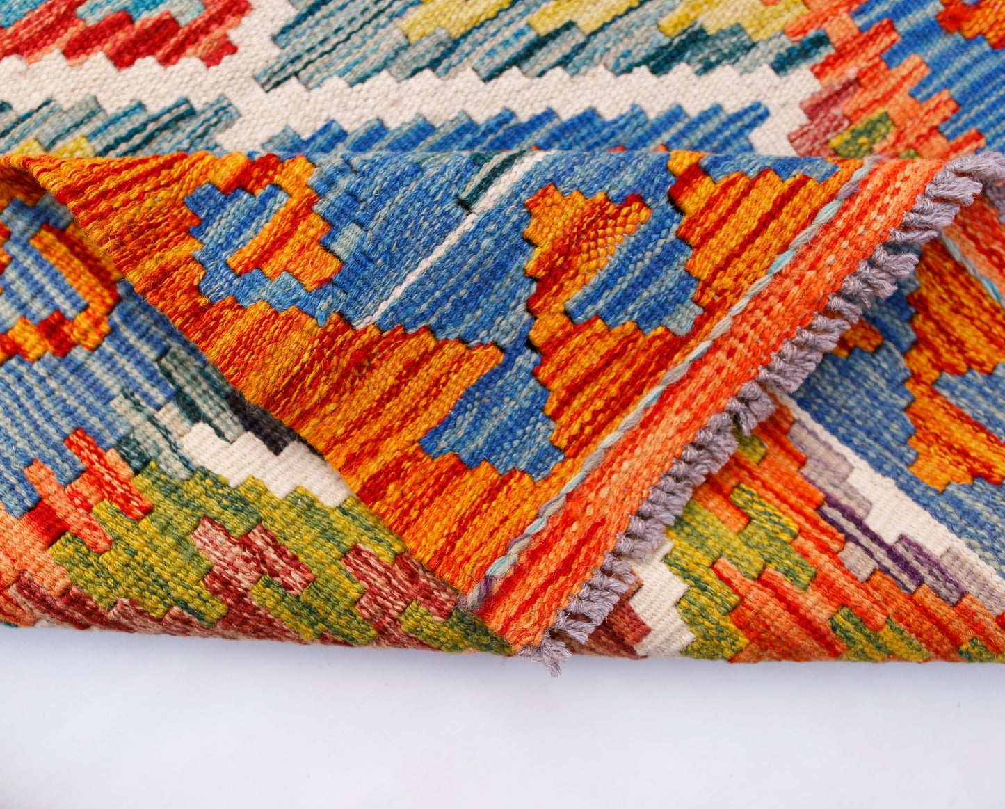 A handwoven Afghan Maimana kilim runner featuring vibrant geometric patterns in wool.