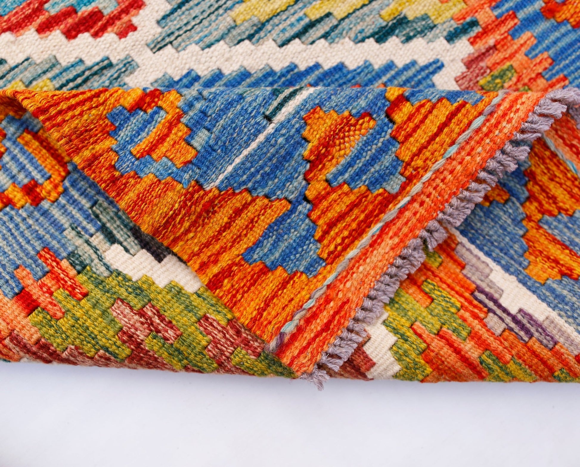 A handwoven Afghan Maimana kilim runner featuring vibrant geometric patterns in wool.