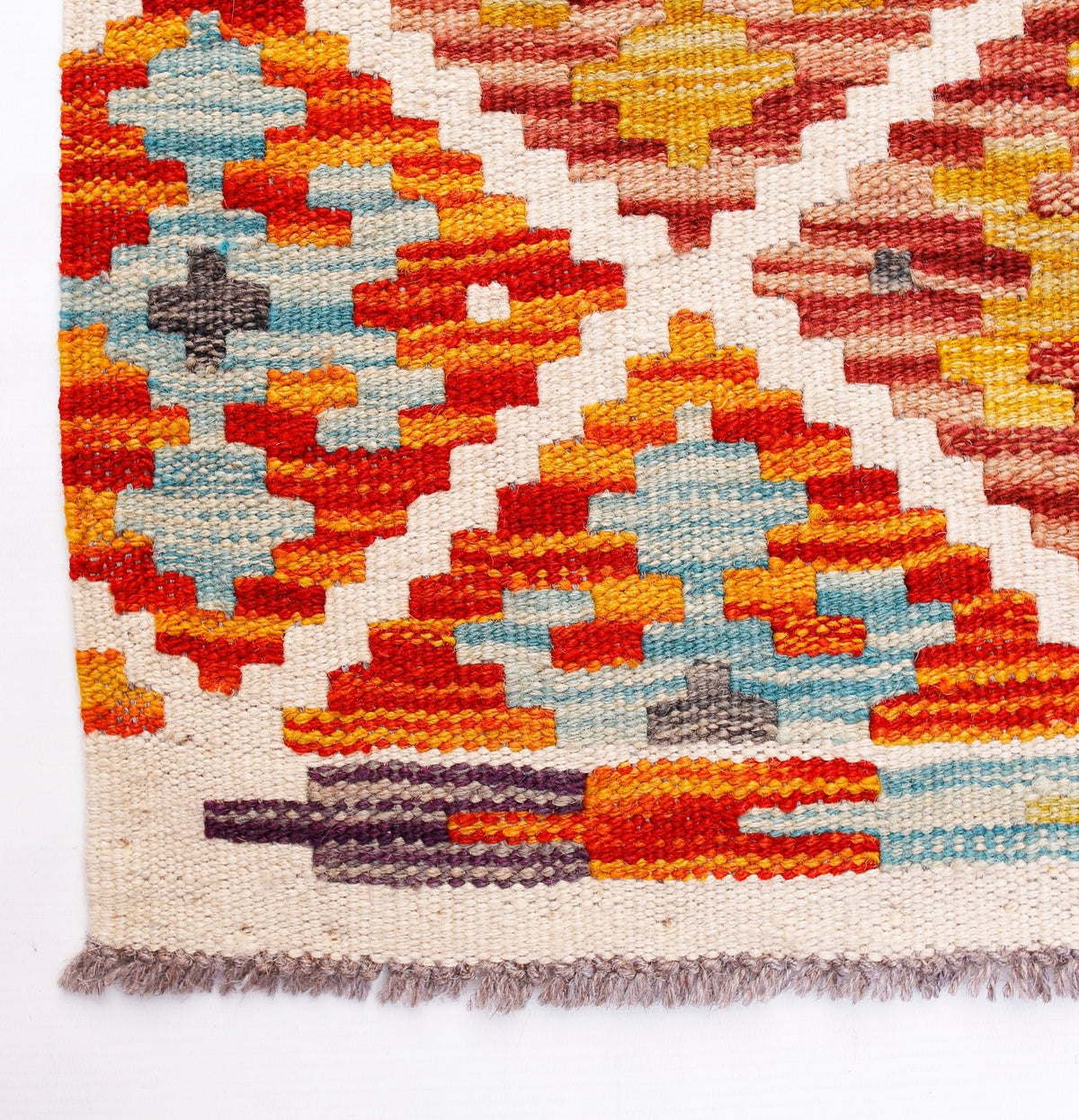Handwoven Afghan Maimana wool runner featuring a vibrant geometric pattern and fringed edges.