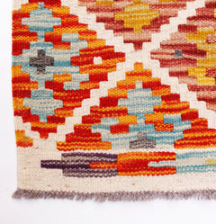 Handwoven Afghan Maimana wool runner featuring a vibrant geometric pattern and fringed edges.
