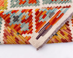 A handmade Afghan Maimana kilim runner featuring a vibrant geometric pattern in wool.
