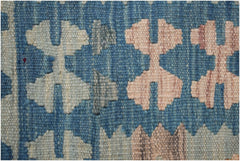 A close-up of a handmade Afghan Maimana kilim runner featuring geometric patterns in blue and tan.