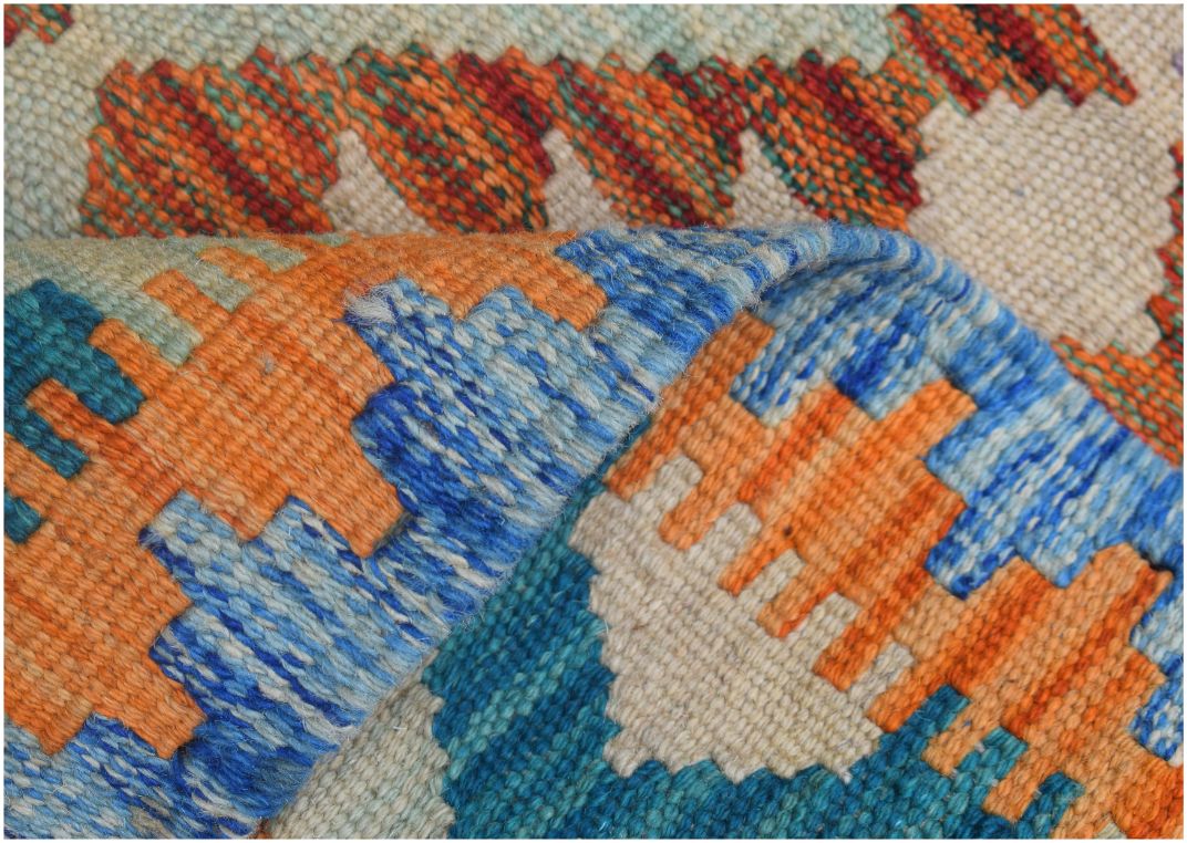A handmade Afghan Maimana kilim runner featuring a geometric pattern in orange, blue, and cream.