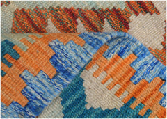 A handmade Afghan Maimana kilim runner featuring a geometric pattern in orange, blue, and cream.