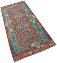A handmade Afghan Maimana Kilim runner featuring a vibrant geometric pattern in blue and orange.