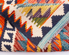 A folded Afghan Maimana Kilim runner featuring vibrant geometric patterns in wool.