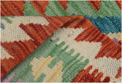 A handmade Afghan Maimana kilim runner featuring a vibrant geometric pattern in wool.