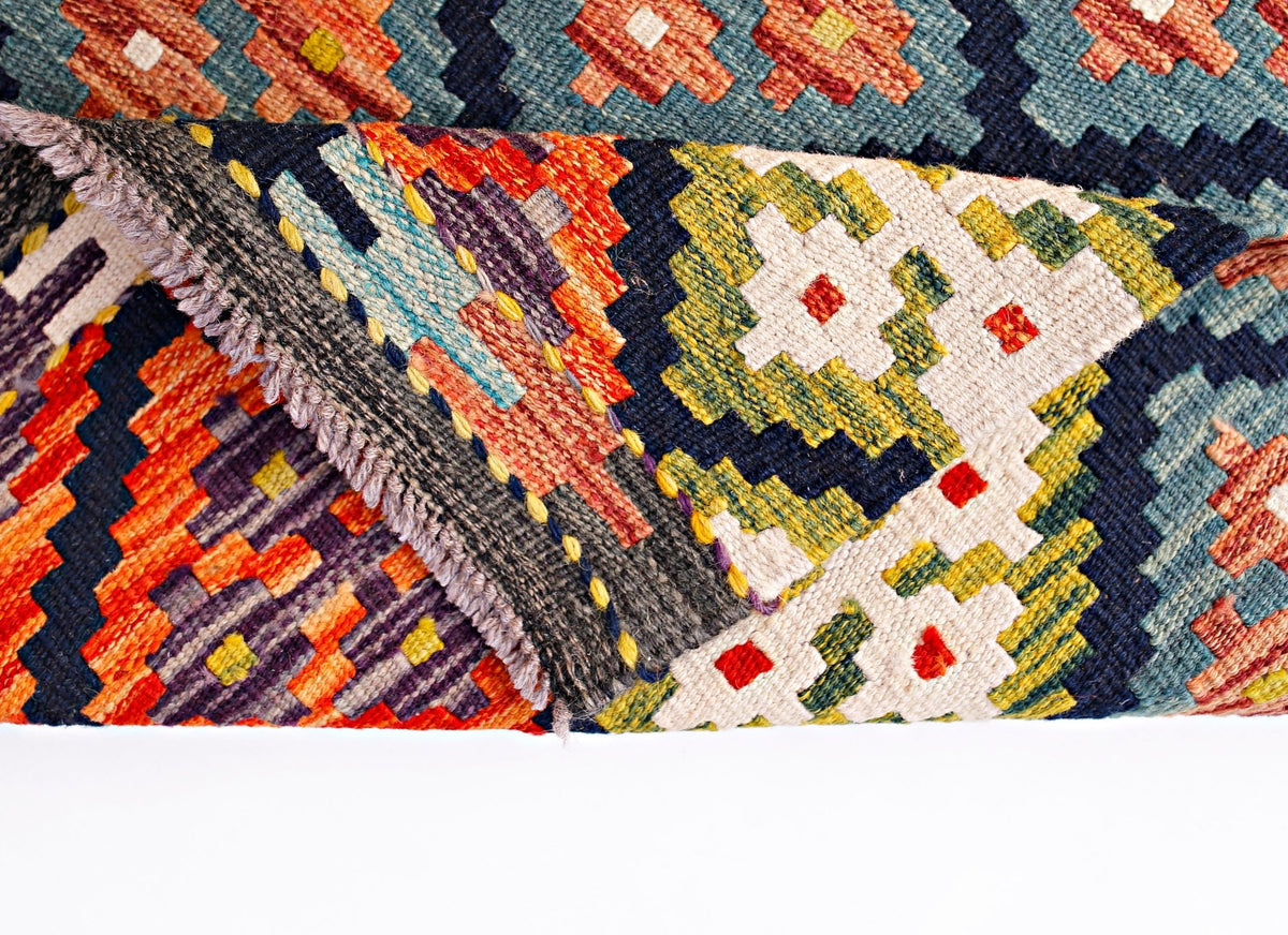 A handwoven Afghan Maimana kilim runner featuring a vibrant geometric pattern in wool.