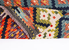 A handwoven Afghan Maimana kilim runner featuring a vibrant geometric pattern in wool.