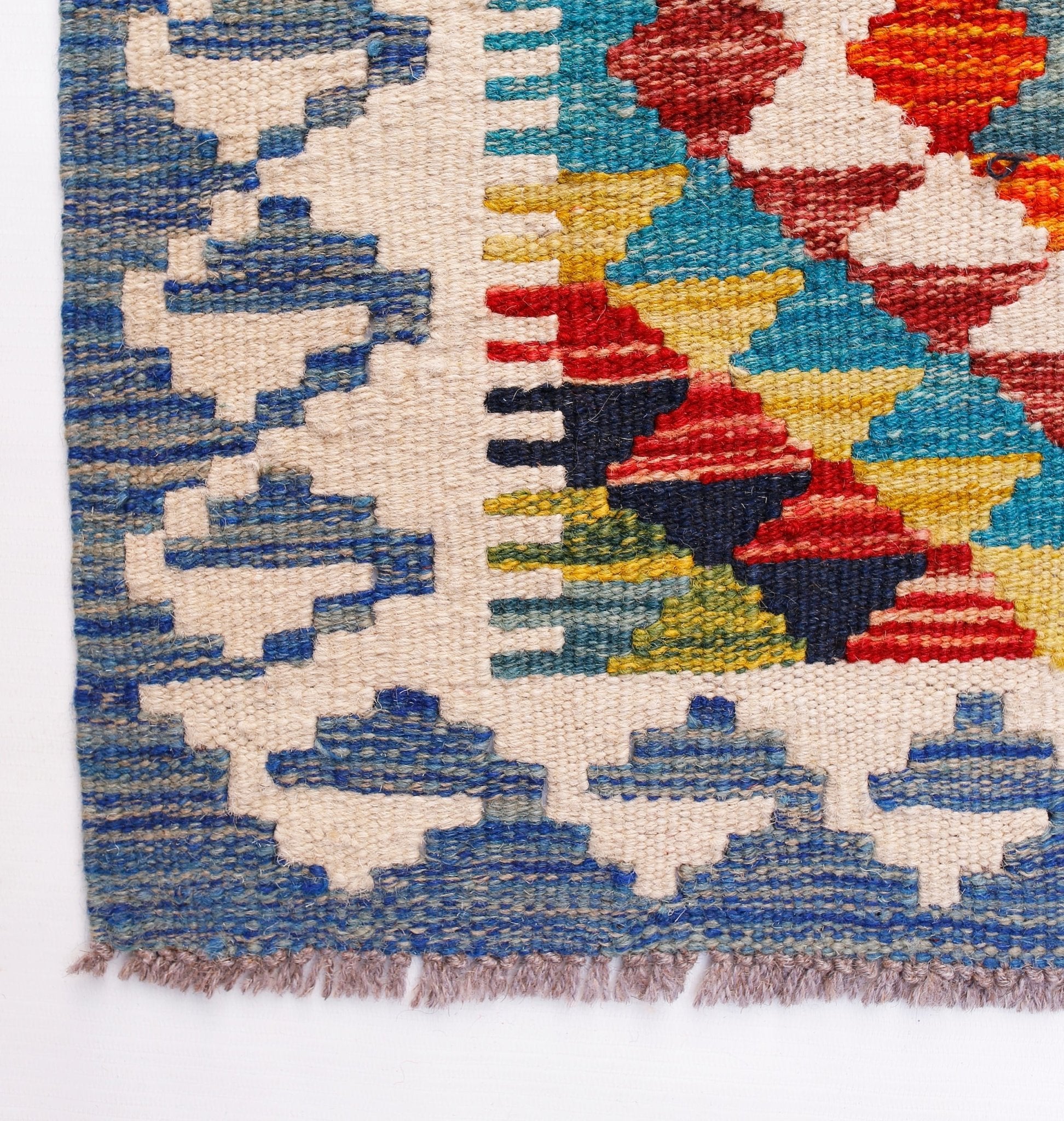 Handwoven Afghan Maimana wool runner featuring a colorful geometric pattern and fringed edges.