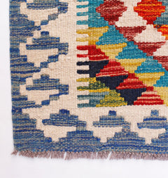 Handwoven Afghan Maimana wool runner featuring a colorful geometric pattern and fringed edges.