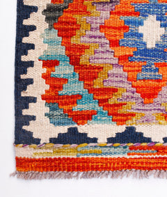 Handwoven Afghan Maimana wool kilim runner featuring a vibrant geometric pattern and fringe ends.