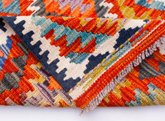 A handwoven Afghan Maimana wool kilim runner featuring a vibrant geometric pattern.