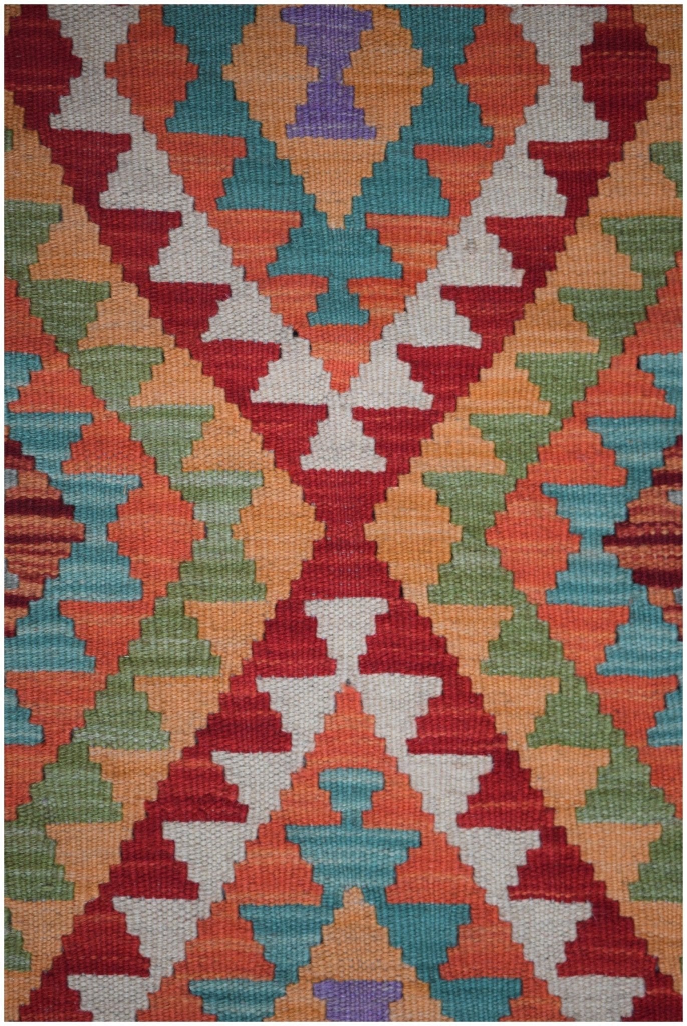 Handmade Afghan Maimana kilim runner featuring a vibrant geometric pattern in multi-colored wool.