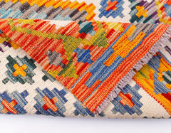 A handmade Afghan Maimana kilim runner featuring a vibrant geometric pattern in wool.