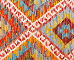 A handmade Afghan Maimana kilim runner featuring a vibrant geometric pattern in wool.