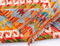 A handmade Afghan Maimana kilim runner featuring a vibrant geometric pattern in wool.