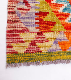 Handwoven Afghan Maimana kilim runner featuring a vibrant geometric pattern in wool.