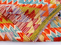 A handwoven Afghan Maimana kilim runner featuring a vibrant geometric pattern in wool.
