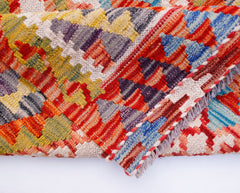 A handwoven Afghan Maimana kilim runner featuring a vibrant geometric pattern in wool.