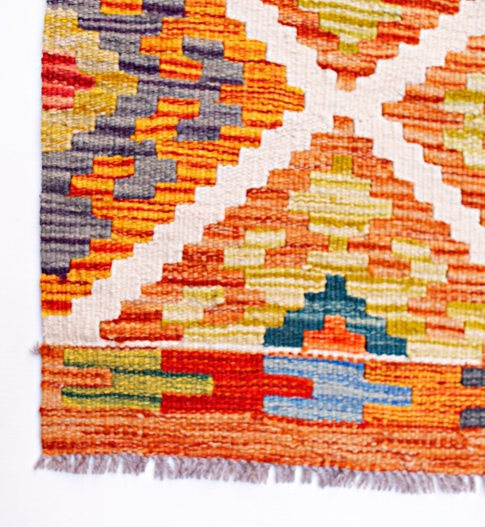 Handwoven Afghan Maimana wool runner featuring a geometric pattern in vibrant multi-colored tones.
