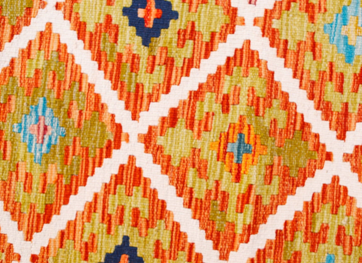A handmade Afghan Maimana kilim runner featuring a geometric diamond pattern in orange, green, and blue.