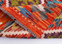 A handwoven Afghan Maimana wool kilim runner featuring vibrant geometric patterns.