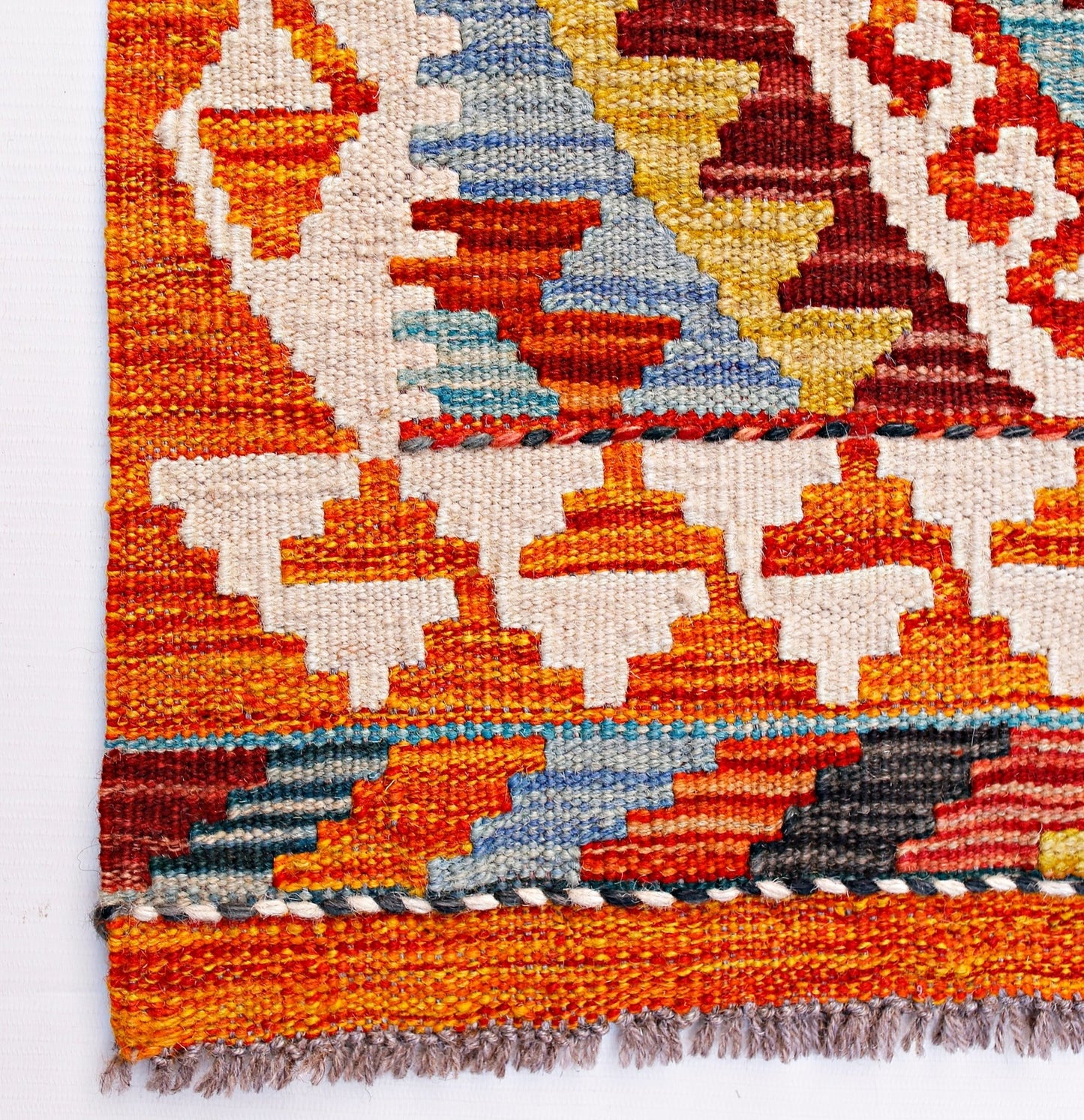 Handwoven Afghan Maimana wool kilim runner featuring a vibrant geometric pattern and fringe ends.